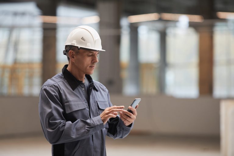 Restoration technician uses a mobile inventory management app on his phone.